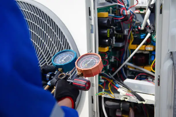 Technician diagnosing warm air problem at residential air conditioner in Manalapan home