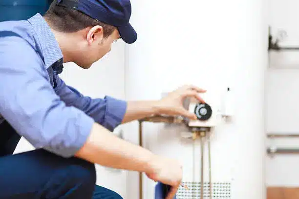 Experienced HVAC technician testing furnace components with meter during urgent repair visit, HVAC technician diagnosing furnace issue with tools in occupied home