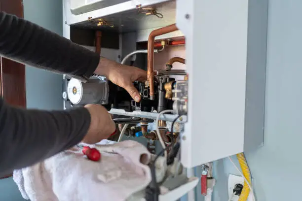 HVAC technician repairing furnace after sudden heating failure in Howell home