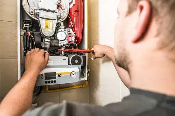 Experienced HVAC technician testing heater controls and airflow during repair