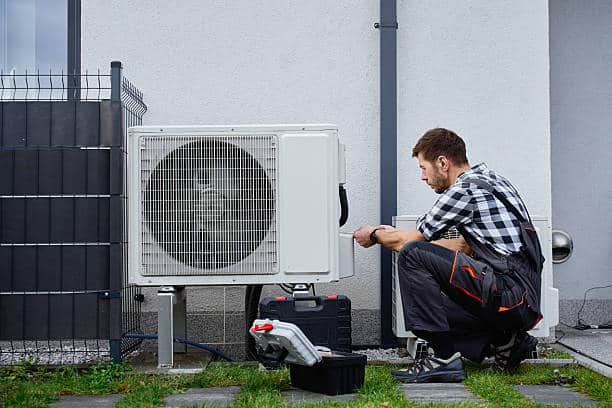 Technician installing new indoor HVAC unit during coastal Long Branch home system replacement