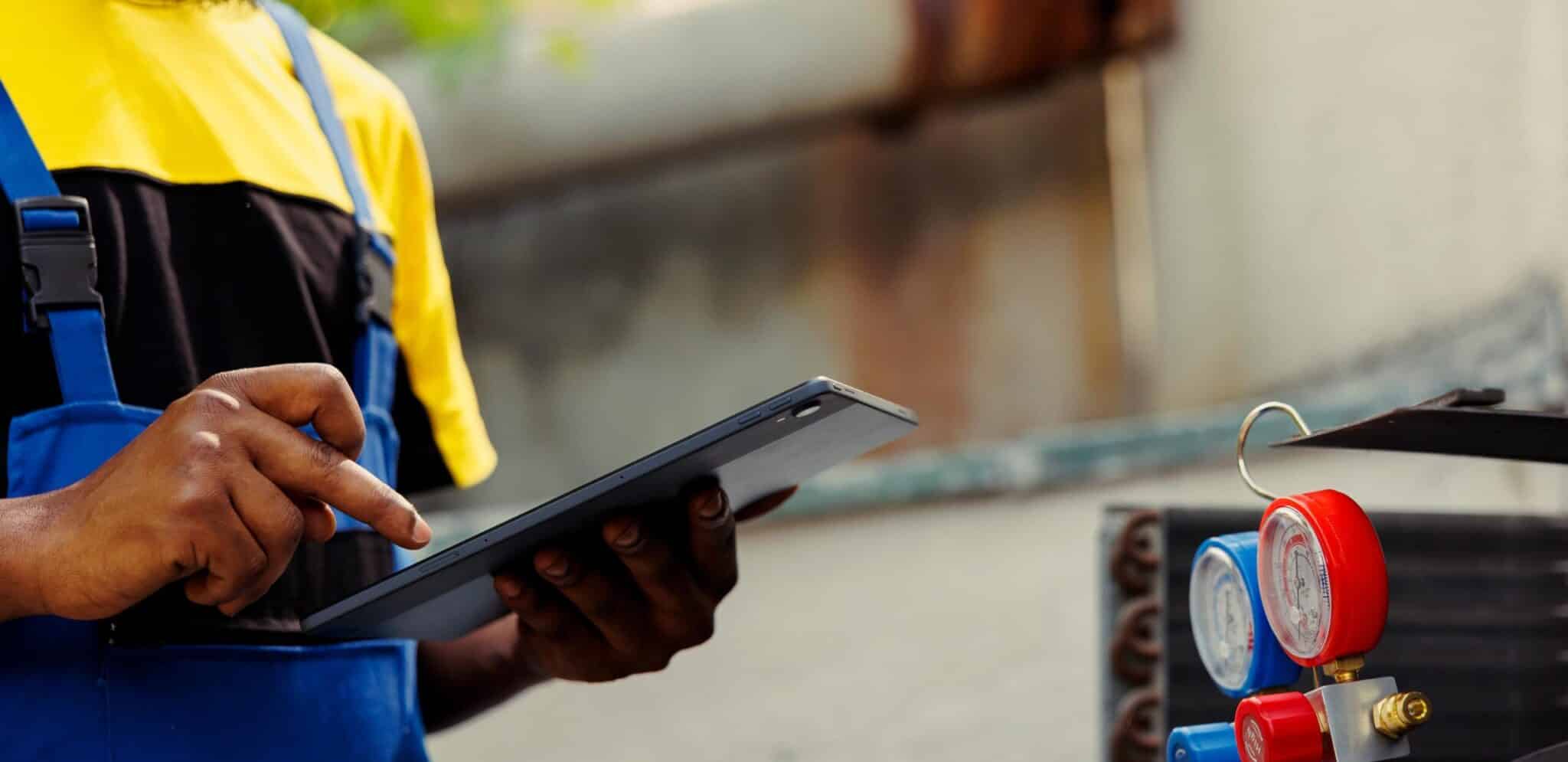 HVAC Heating Air Conditioning Services New Jersey Monmouth Edison Middlesex Hudson Newark Essek, Skilled HVAC professional inspecting electrical components and airflow settings inside indoor unit