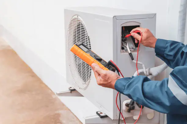 Skilled technician testing AC system performance with gauges and diagnostic tools